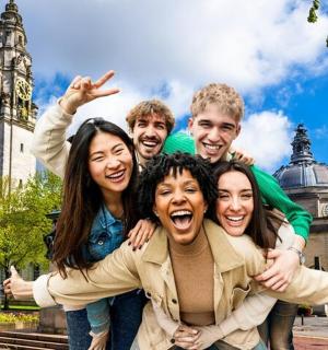 a group of people posing for a picture in front of a clock tower