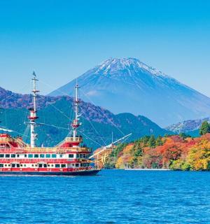 水上的一艘船，背景是一座山