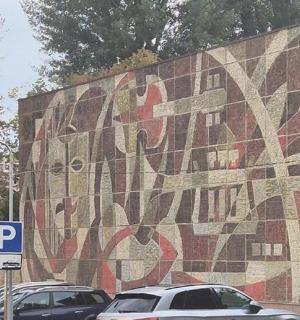 一面马赛克墙，上面画着停在停车场里的汽车