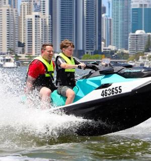 two men riding on a jet ski in the water