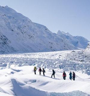 一群人穿过一座白雪皑皑的山峰
