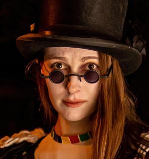 a woman wearing a top hat and sunglasses
