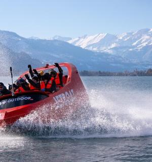 一群人坐在水上的红船上