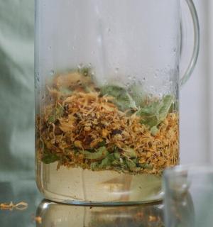 桌子上放着一个装满食物的玻璃搅拌机。