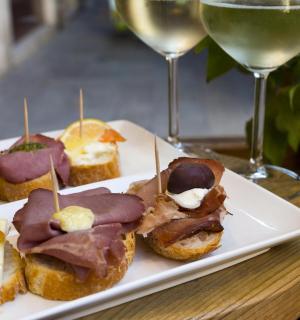 a plate of pastries and two glasses of wine