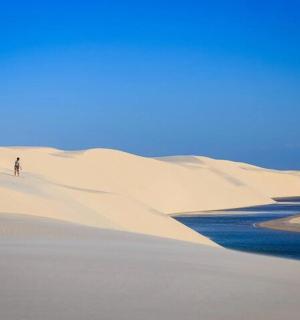 a person walking on a sand dune in the desert