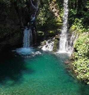 a waterfall in the middle of a pool of water