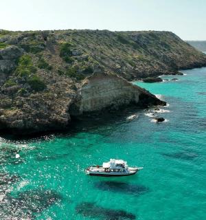 a boat in the water next to a rocky coast