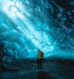 站在冰洞前的人