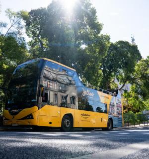 a yellow double decker bus driving down a street