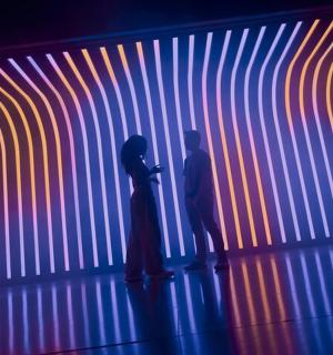 two people standing in front of a colorful wall