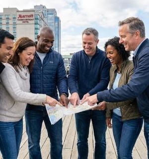 ryhmä ihmisiä seisoo ryhmässä ja pitää karttaa kädessään