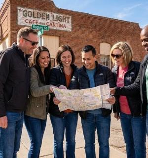 a group of people standing together holding a map