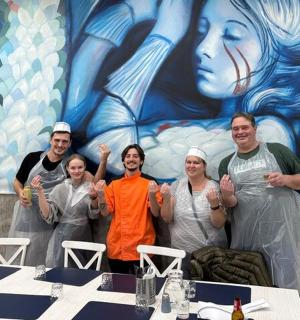 a group of people clapping in front of a painting