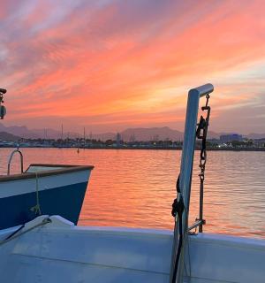 човен на воді із заходом сонця на задньому плані