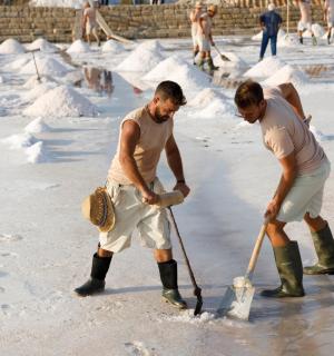 Zwei Männer spielen mit einer Schaufel im Schnee.