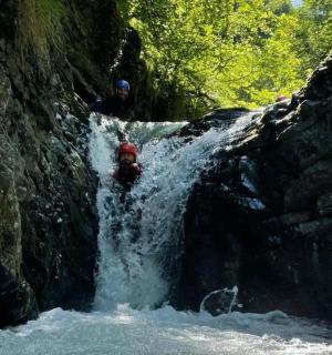zwei Menschen stehen in einem Wasserfall in einem Fluss