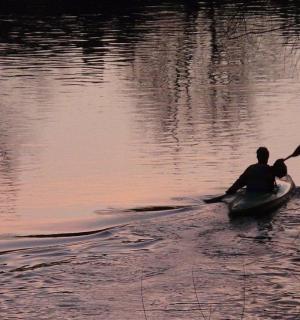 ein Mann rudert ein Kanu auf dem Wasser