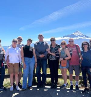 eine Gruppe von Menschen posiert für ein Foto vor einem Berg