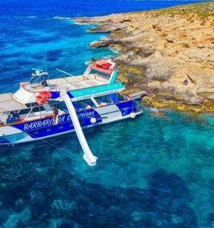 ein Boot, das neben einer Klippe im Wasser schwimmt