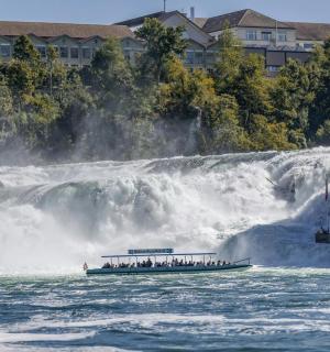 μια ομάδα ανθρώπων σε μια βάρκα μπροστά από έναν καταρράκτη