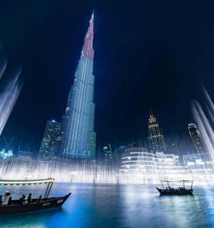 a group of people in a boat in front of a fountain