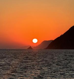 ein Sonnenuntergang über dem Wasser mit Bergen im Hintergrund