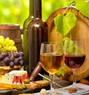 dwie szklanki wina obok beczki winogron