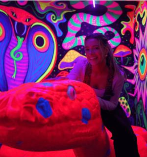 une femme assise sur un pouf devant un tableau