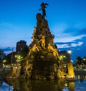 eine Statue eines Mannes, der auf einem Brunnen steht