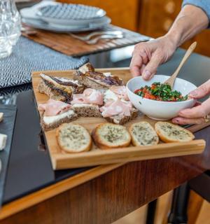 osoba držící misku s jídlem na prkénku