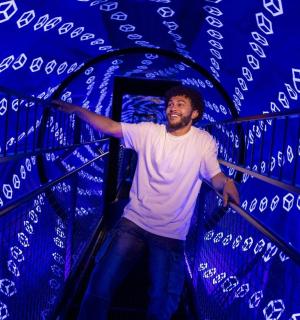 Muž stojí v místnosti s modrou zdí