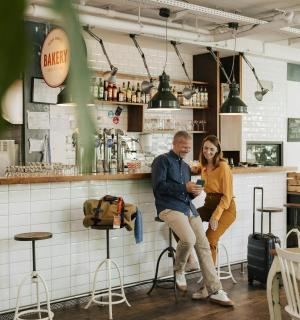 ชายและหญิงนั่งอยู่ที่บาร์