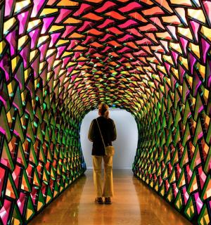 Žena prochází tunelem barevného umění