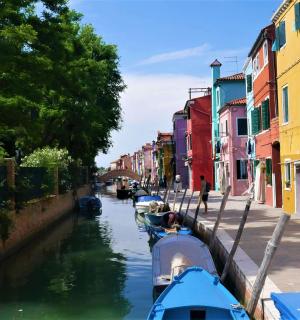 Dva čolna sta privezana na kanalu z barvitimi stavbami