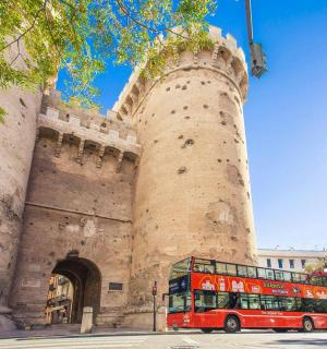 červený dvoupatrový autobus zaparkovaný před hradem