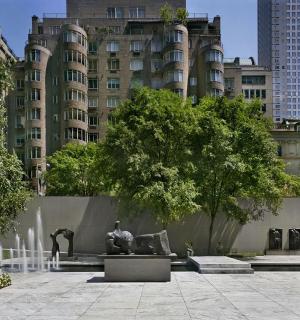 en park med statuer foran en stor bygning