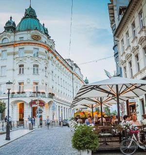 건물이 있는 거리를 자전거를 타고 가는 여자