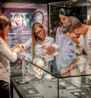 tres persones mirant un expositor en una vitrina