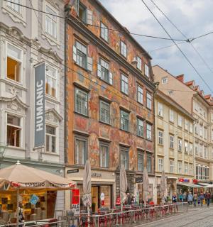 zgrada na ulici sa stolovima i zgradama