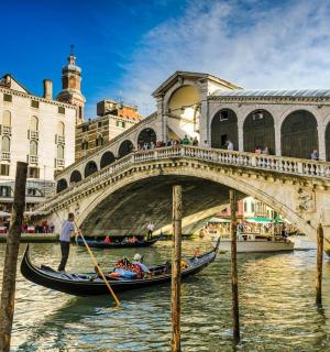 en gondol i en kanal foran en bro