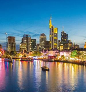 เส้นขอบฟ้าของเมืองในยามค่ำคืนพร้อมแม่น้ำและเรือ