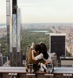 una pareja sentada en el borde de un edificio