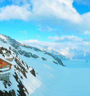 ένα χιονισμένο βουνό με ένα σπίτι στην κορυφή του