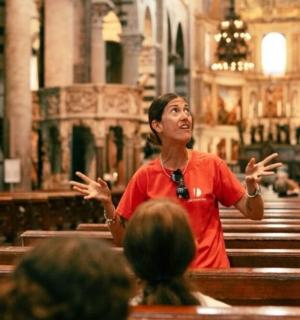 seorang wanita berdiri di hadapan sekumpulan orang di sebuah gereja