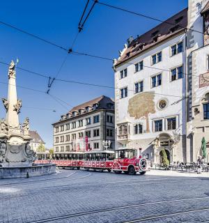 ein roter Bus auf einer Stadtstraße mit Gebäuden