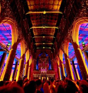 色鮮やかな天井のある広い部屋に集まった大勢の人々