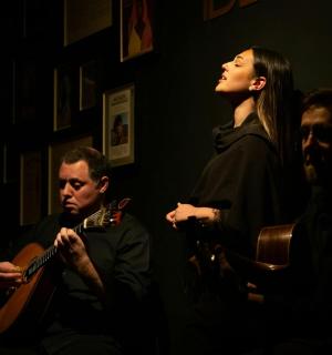 eine Frau steht neben einem Mann, der Gitarre spielt