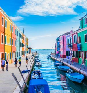 sekumpulan bangunan berwarna-warni di sebelah terusan dengan bot