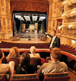 un home dret davant d'una multitud en un auditori